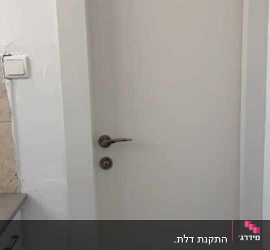 דלת לבנה עם ידית מתכת